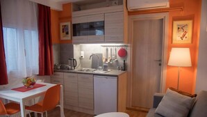 A compact living space with a kitchenette, dining area, and a sofa. - Ancient Thissio by GHH (Athens)