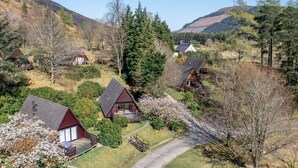 A cluster of wooden cabins with sloped roofs, surrounded by trees and hills. - Wonderful private villa for 4 guests with WIFI, TV, balcony and panoramic view (Kilfinnan)