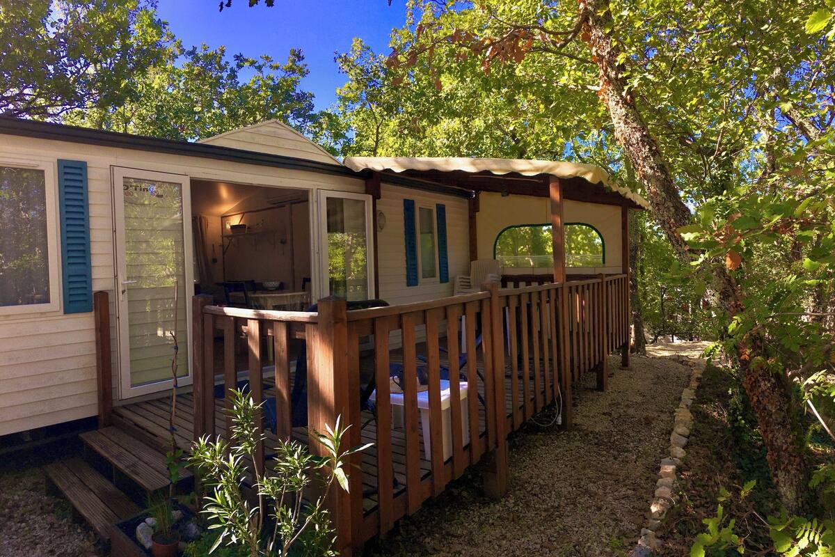 A row of mobile homes with wooden decks and a covered porch area.