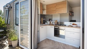 A modern kitchen with white cabinets, a stainless steel stove, and a wooden countertop. - Domaine le Clos des Capitelles (Saint-Privat-de-Champclos)