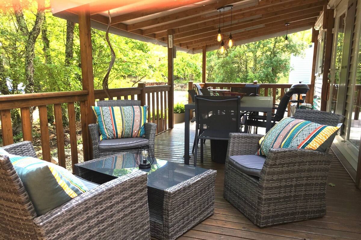 An outdoor deck with wicker furniture, a table, and chairs.