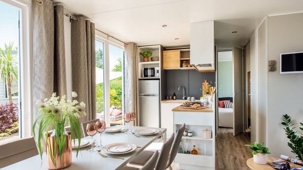 A modern kitchen with a built-in microwave, a refrigerator, and a wooden countertop. - Domaine le Clos des Capitelles (Saint-Privat-de-Champclos)