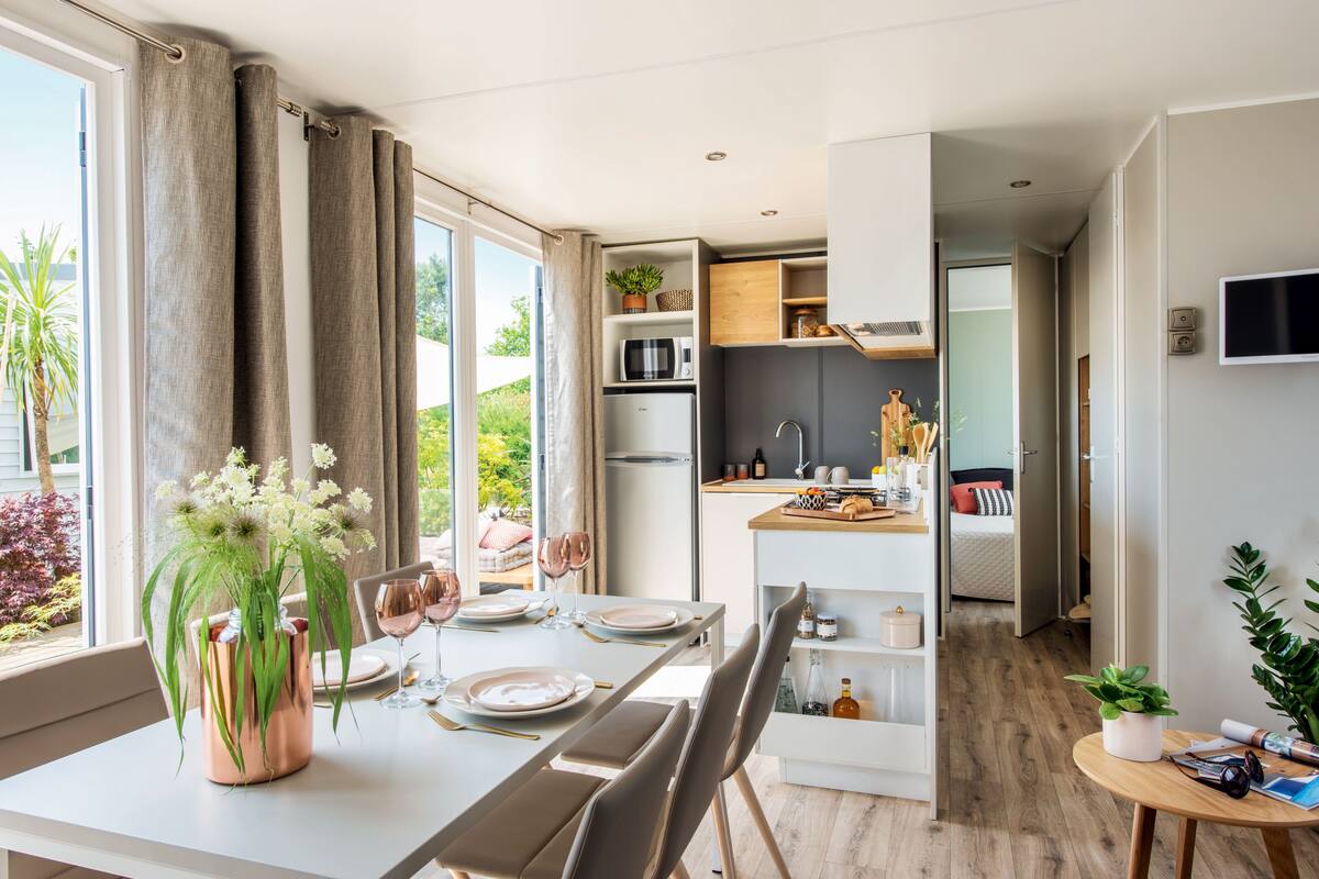 A modern kitchen with a built-in microwave, a refrigerator, and a wooden countertop.