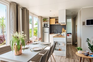 Una cocina moderna con microondas integrado, refrigerador y encimera de madera.