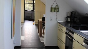 A narrow kitchen with a black floor, yellow cabinets, and a skylight.