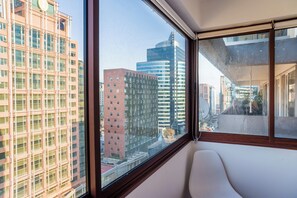 Una habitación con un amplio ventanal que ofrece vistas de edificios altos y un paisaje urbano.