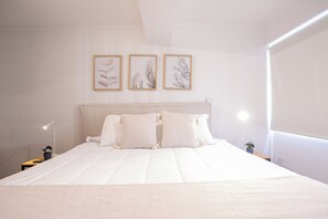 A neatly made bed with white linens and pillows, a bedside lamp, and three framed botanical prints on the wall. - Spacious 2BR/2BA Apt. in the Heart of Las Condes (Las Condes)