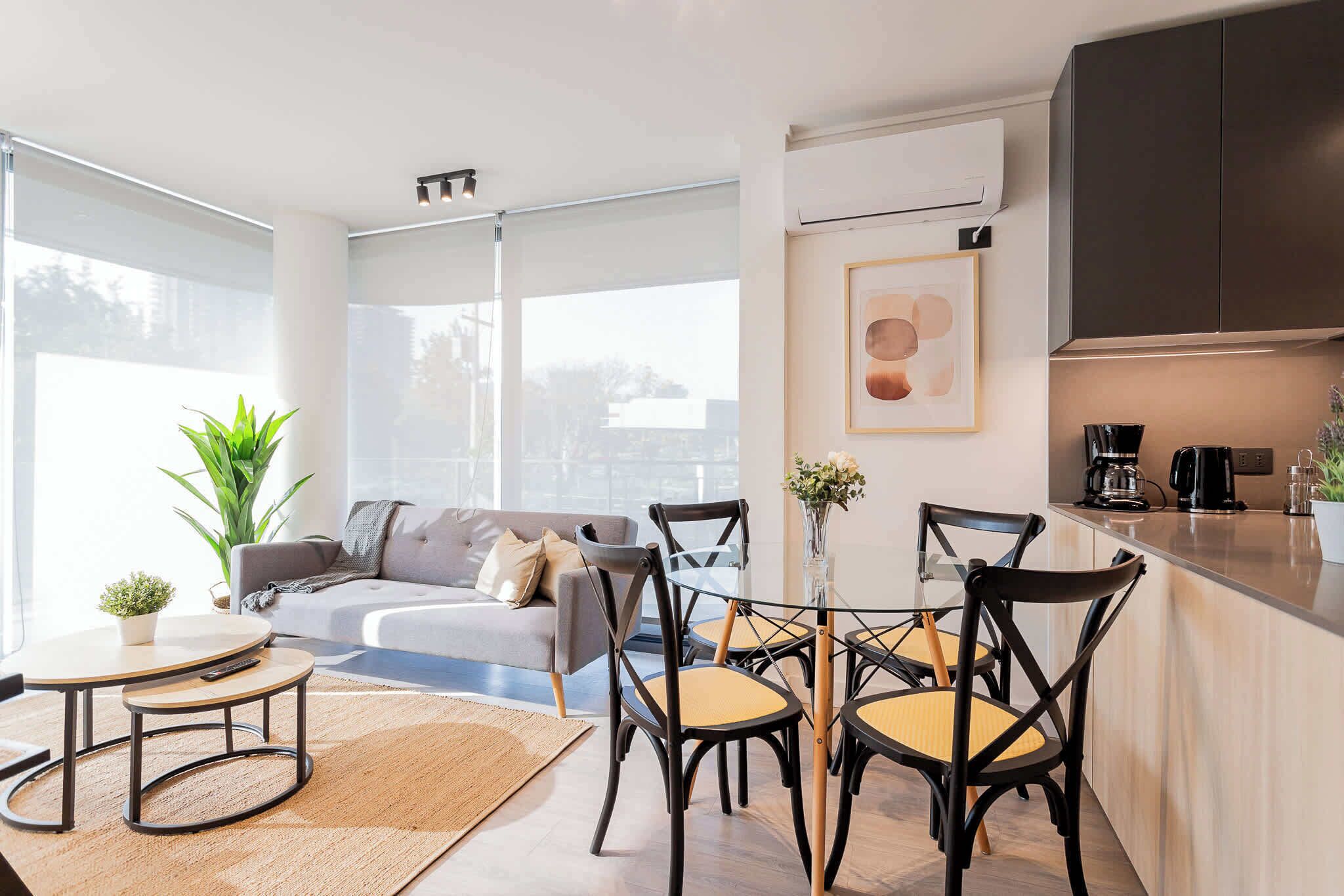 Een moderne woonkamer met een bank, stoelen, een salontafel en een eettafel.
