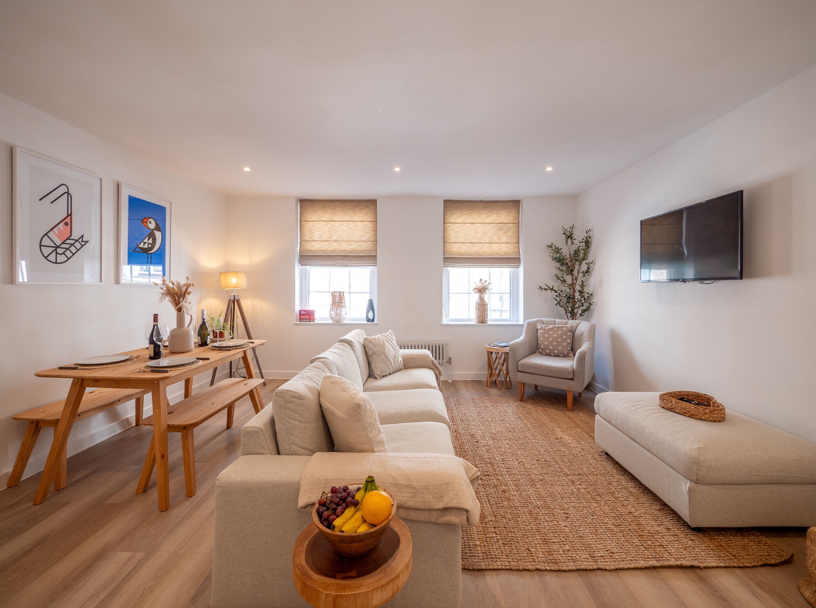 Ein modernes Wohnzimmer mit einer Couch, einem Esstisch und einem Fernseher.