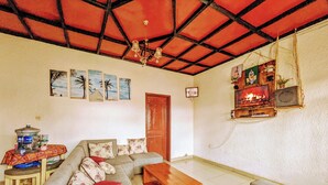 A living room with a sofa set, a wooden coffee table, and a fireplace. - Rand's House I Homestay (Ruhengeri)
