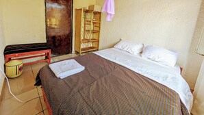 A room with a bed, a bench, a shelf, and a door. - Rand's House I Homestay (Ruhengeri)