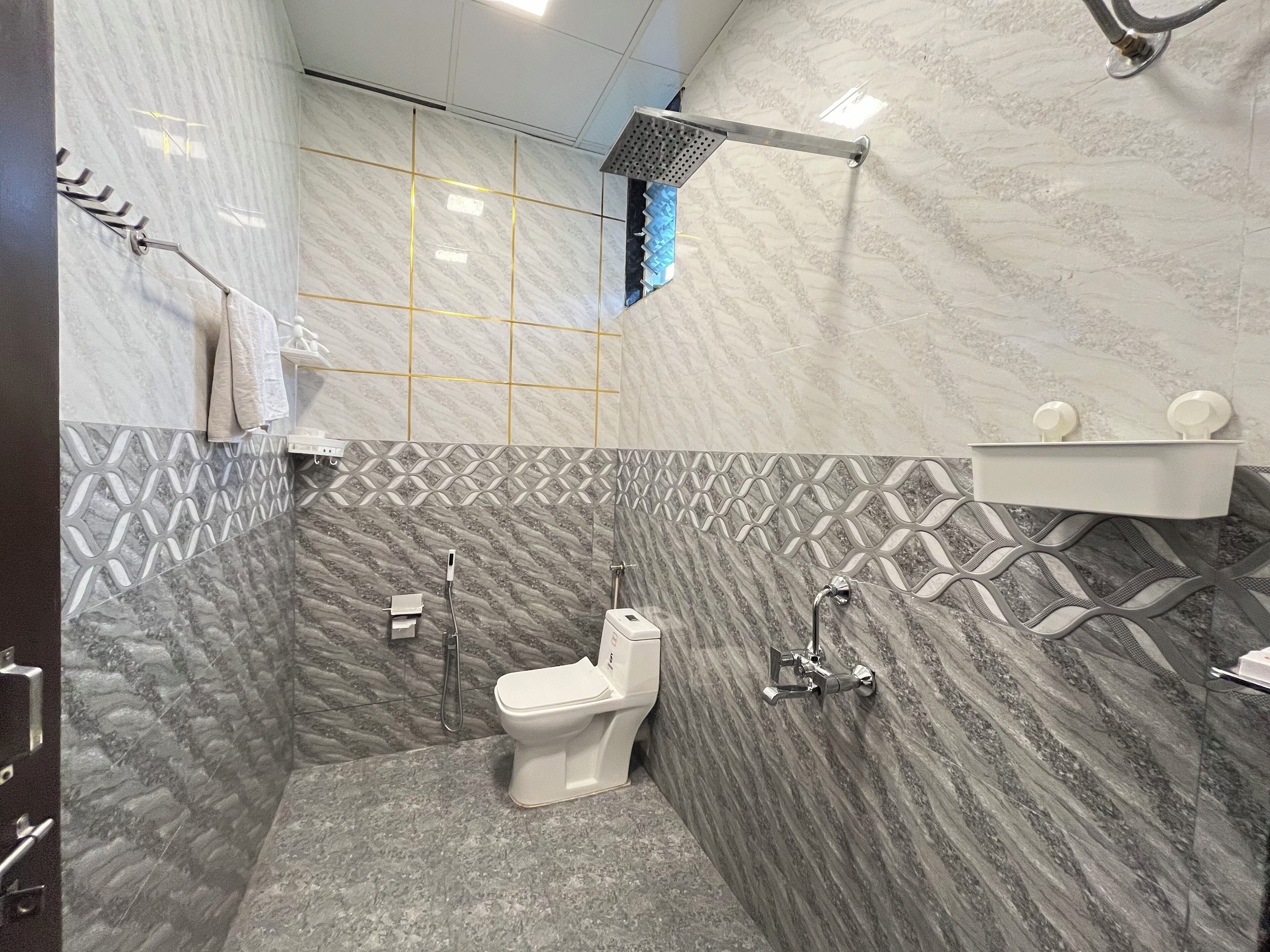 A modern bathroom with a shower, toilet, and sink.