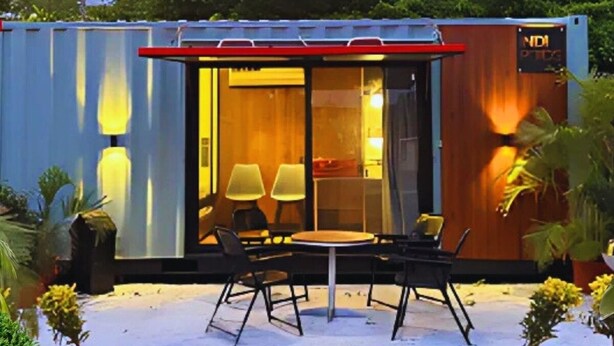 Un espacio al aire libre compacto y moderno con una mesa y sillas, rodeado de plantas en macetas y un ventanal grande.
