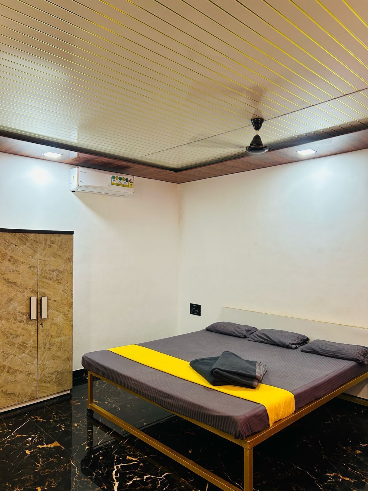 A bedroom with a bed, a wardrobe, and a ceiling fan.