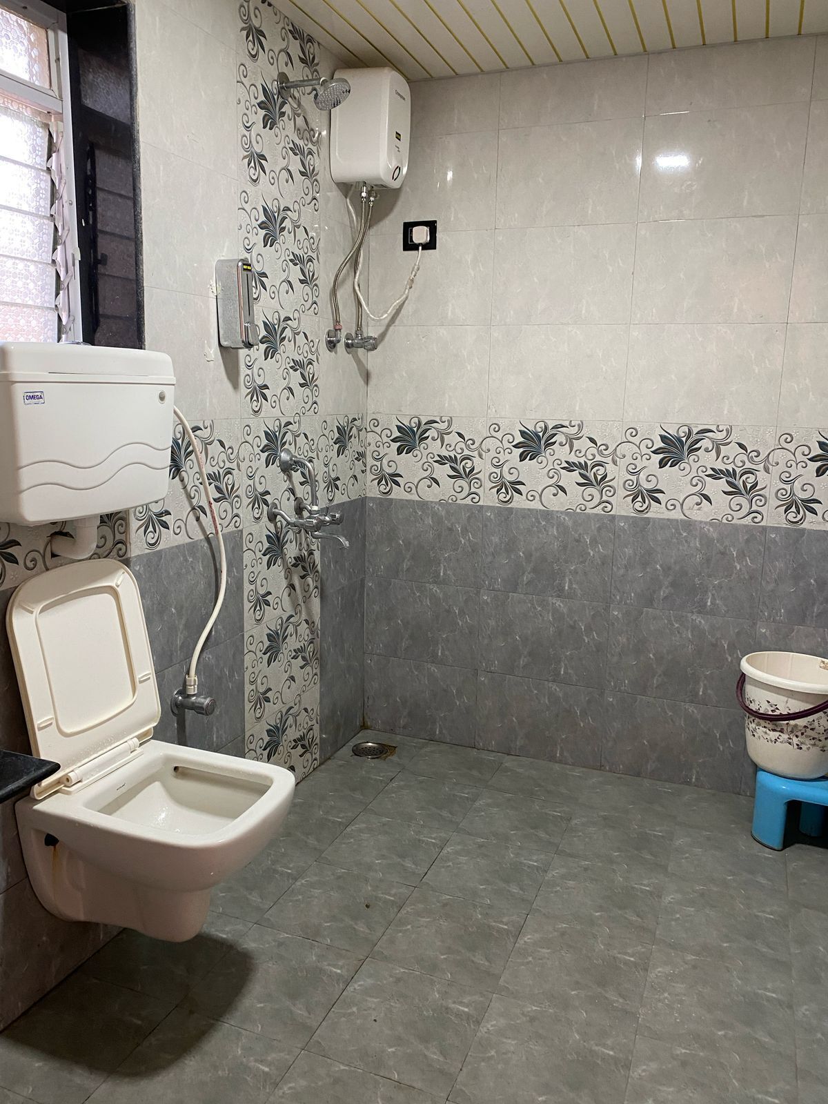 Un baño con inodoro, ducha y calentador de agua.