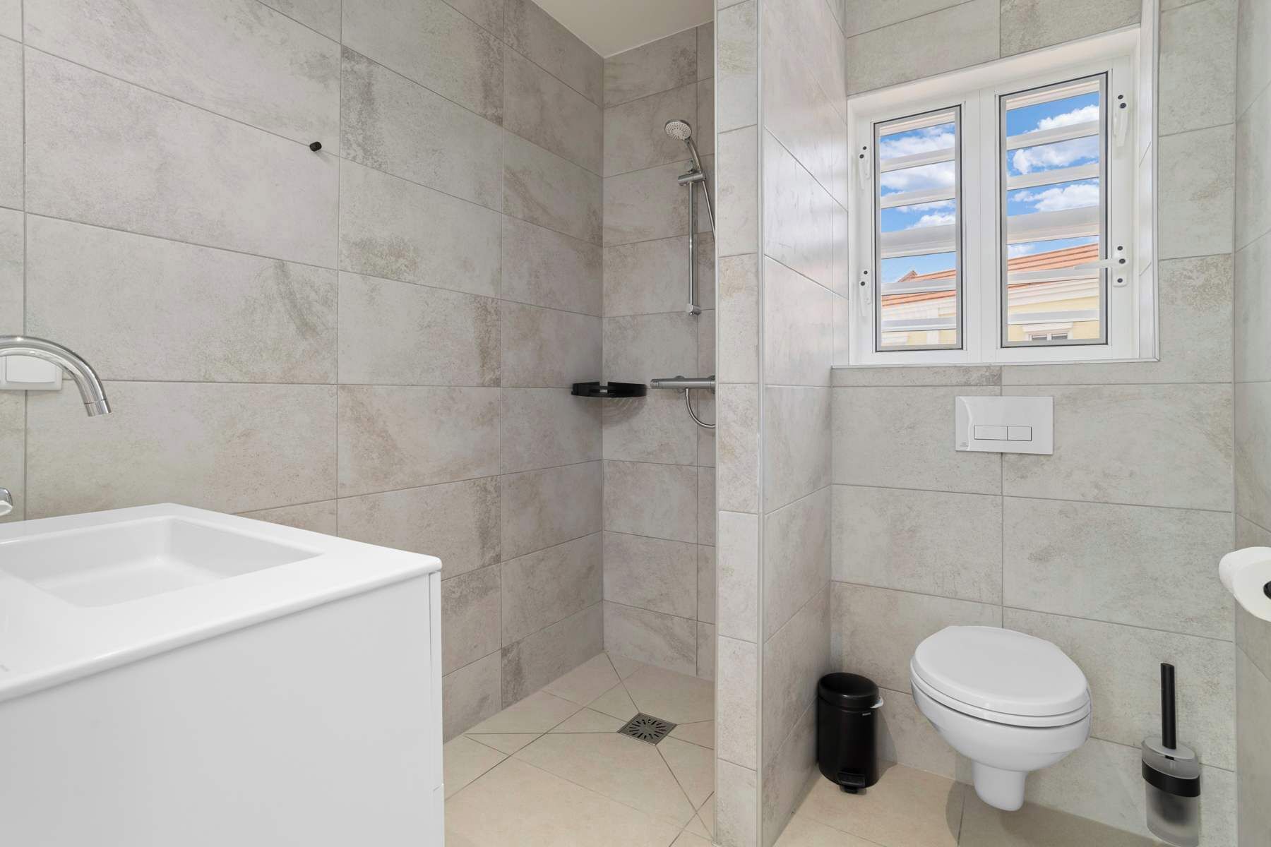 A bathroom with a shower, toilet, and sink.