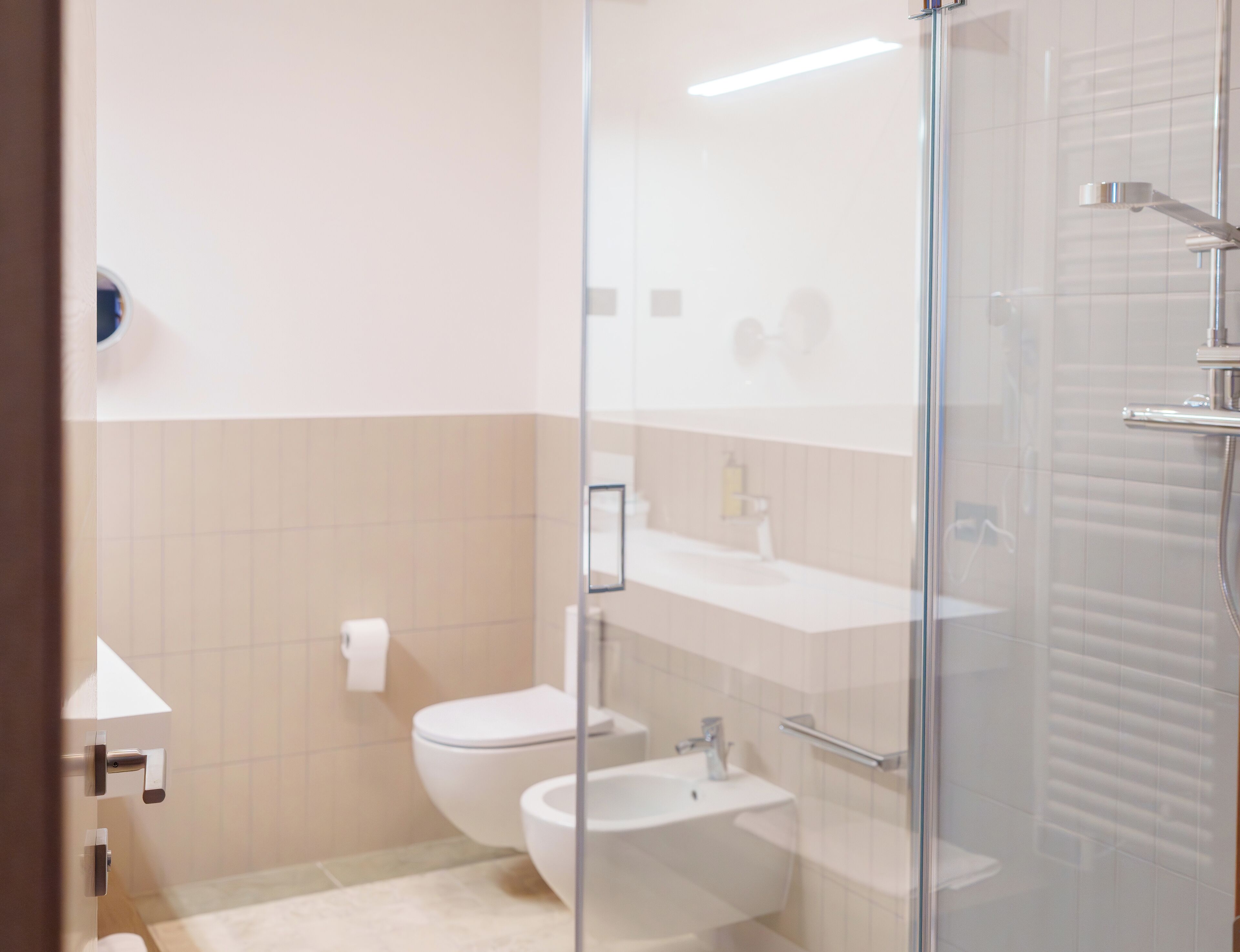 Une salle de bain moderne avec une douche à parois de verre, des toilettes et un lavabo.