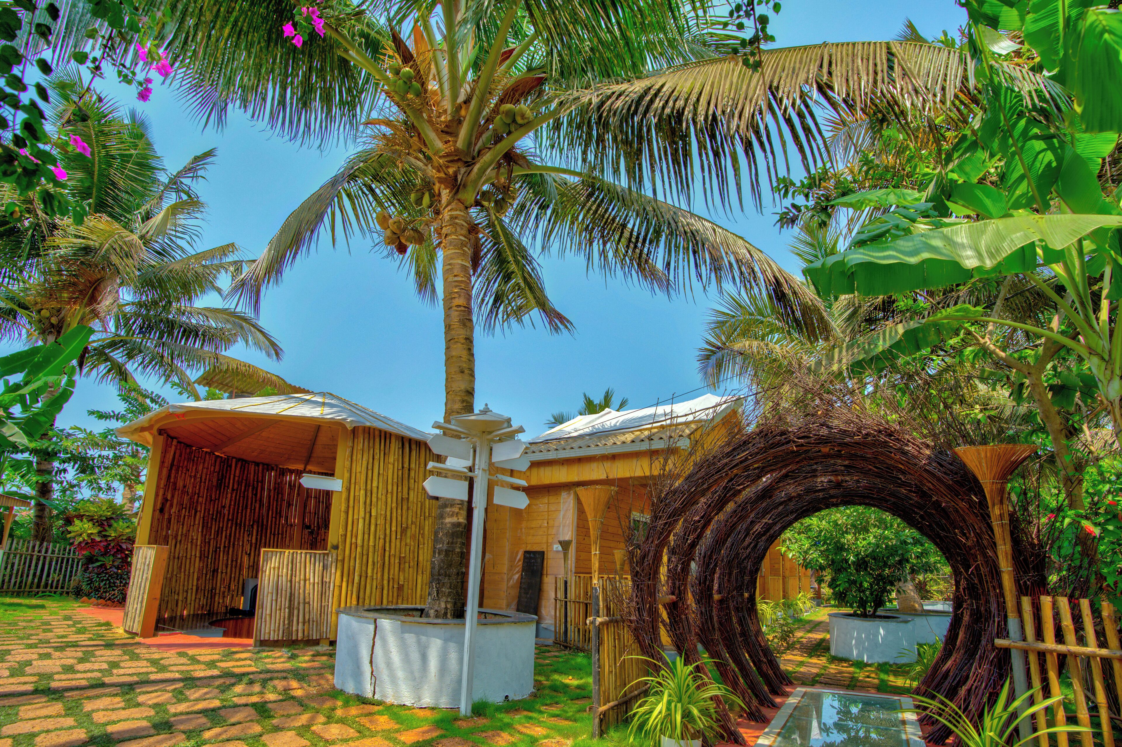 A tropical resort with a bamboo structure, palm trees, and a checkered floor.