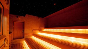 Een sauna met houten banken en een sterrenhemel.