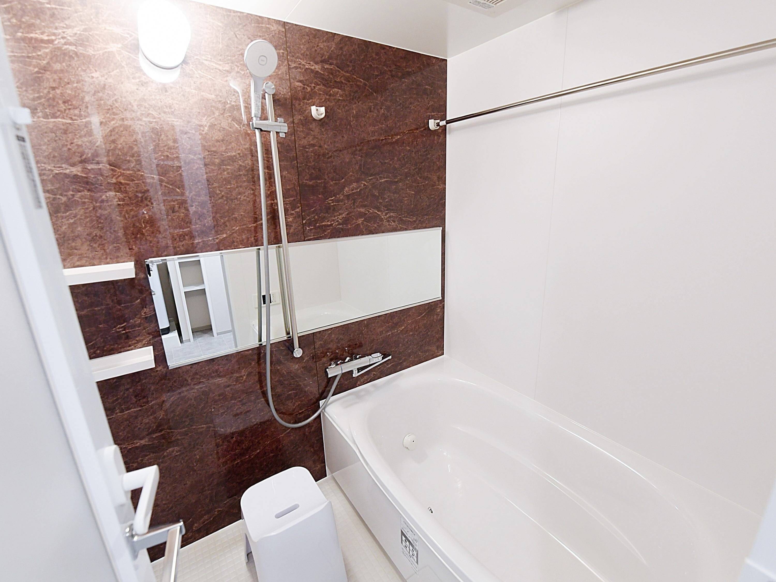 Une salle de bain moderne avec une baignoire, une douche et un miroir.