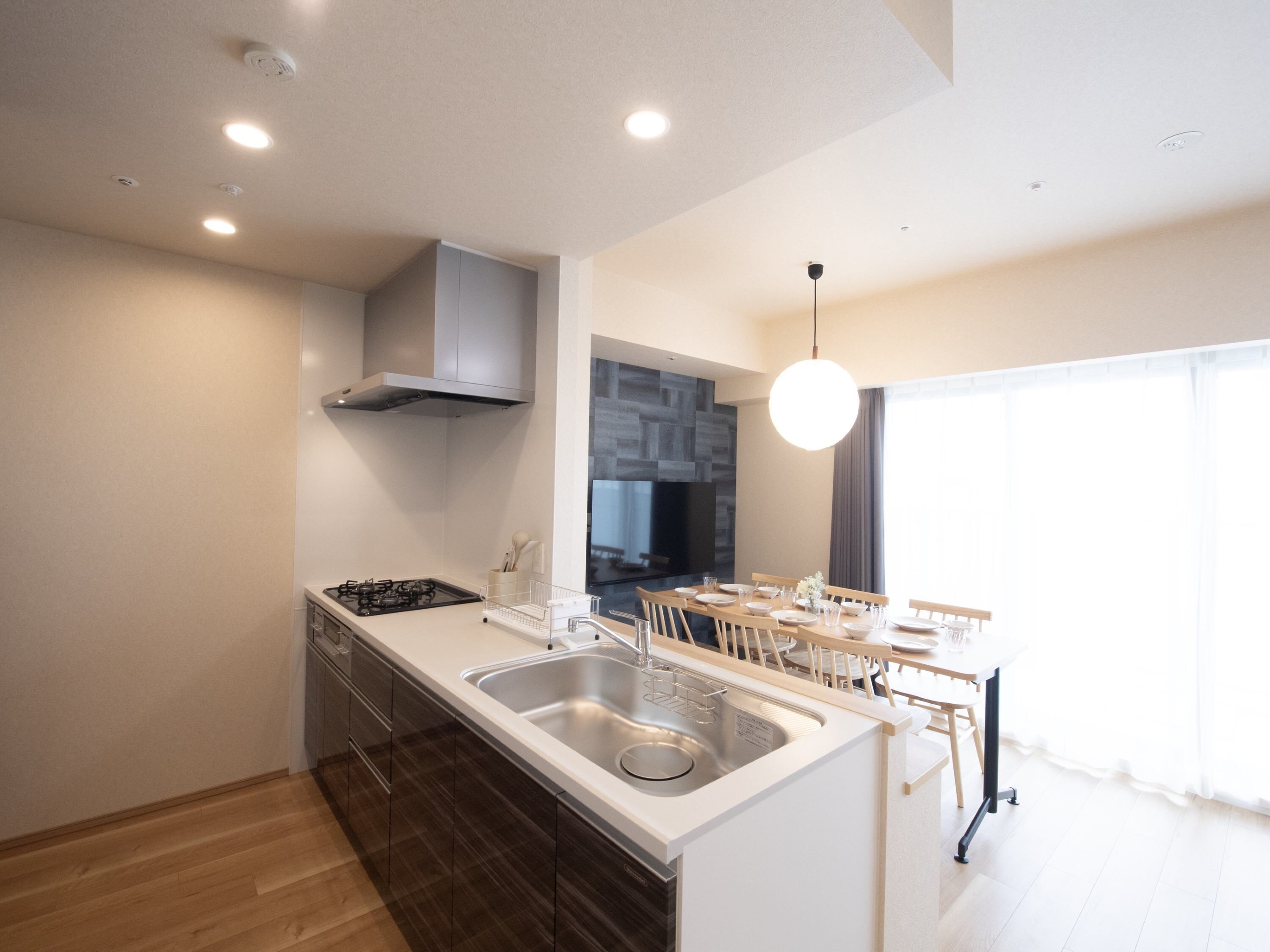 Una cocina moderna con una isla central, un lavamanos de acero inoxidable y un horno empotrado.