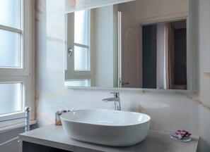 Habitación triple de lujo, vista a la ciudad | Baño | Regadera, amenidades de baño gratuitas, secadora de cabello, pantuflas 