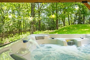 A hot tub with a view of a forested area.