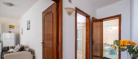 Una habitación con un sofá, un armario y una puerta que da a un baño.