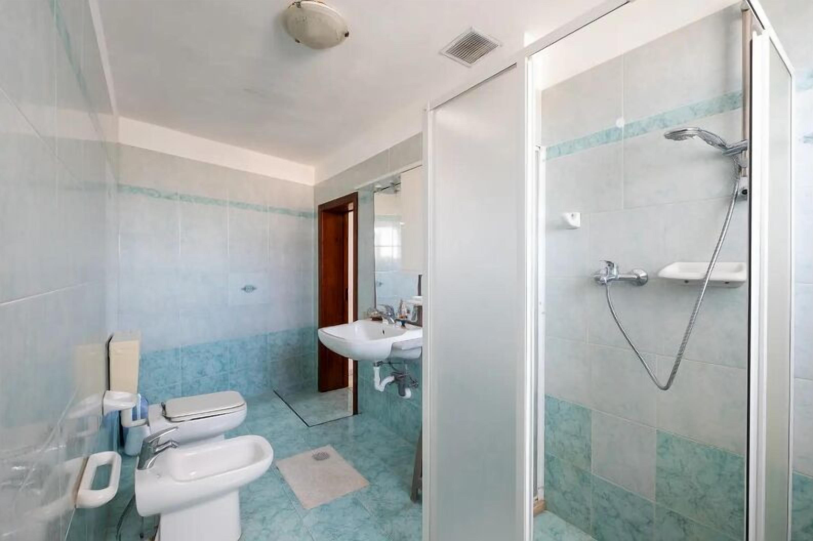 Un baño con ducha, lavabo e inodoro.