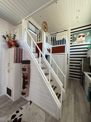 A staircase with white railings and wooden steps leading to a landing.