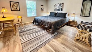 A bedroom with a bed, a desk, a chair, a standing lamp, a ceiling fan, and a window. - Covered JM Ranch - 3BR/2BA - Family Friendly (Lubbock)