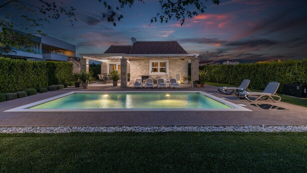 A modern house with a swimming pool, a patio with chairs, and a view of the sky. - Villa Stina Zadarvillas (Sukosan)