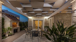 An outdoor patio with a stone fireplace, a dining table with chairs, and potted plants. - Villa Stina Zadarvillas (Sukosan)