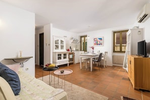 A compact living space with a kitchenette, dining area, and a sofa. - Apartment Dei Fiori 1 (Rovinj)