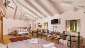 Ein Schlafzimmer mit einem Bett, einem Schreibtisch, einem Sessel, einer Couch und einem Fernseher.
