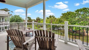 A covered outdoor area with wooden Adirondack chairs and a pool table. - Rooftop Deck, Soaring Views & Steps to Tybee’s Best Beaches by Tybee Cottages (Tybee Island)