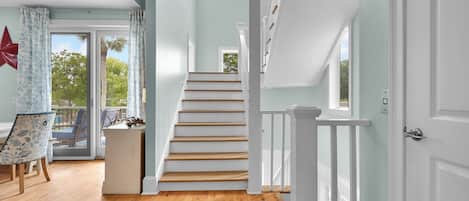 Stunning interior with a staircase, dining area, and large window.