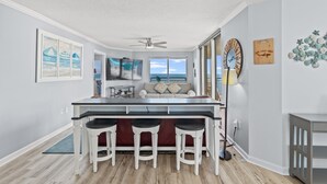 Een moderne keuken met een bar, een plafondventilator en uitzicht op de oceaan.