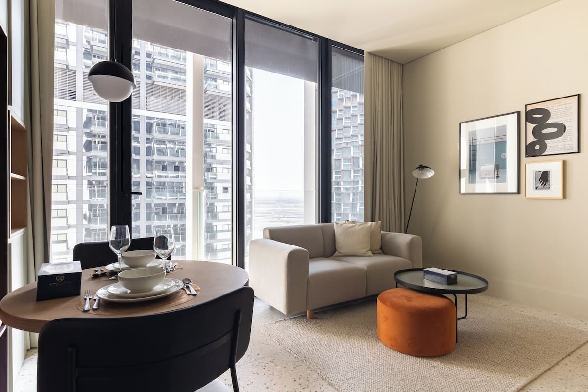 A modern hotel room with a dining area, a sofa, and a small table.