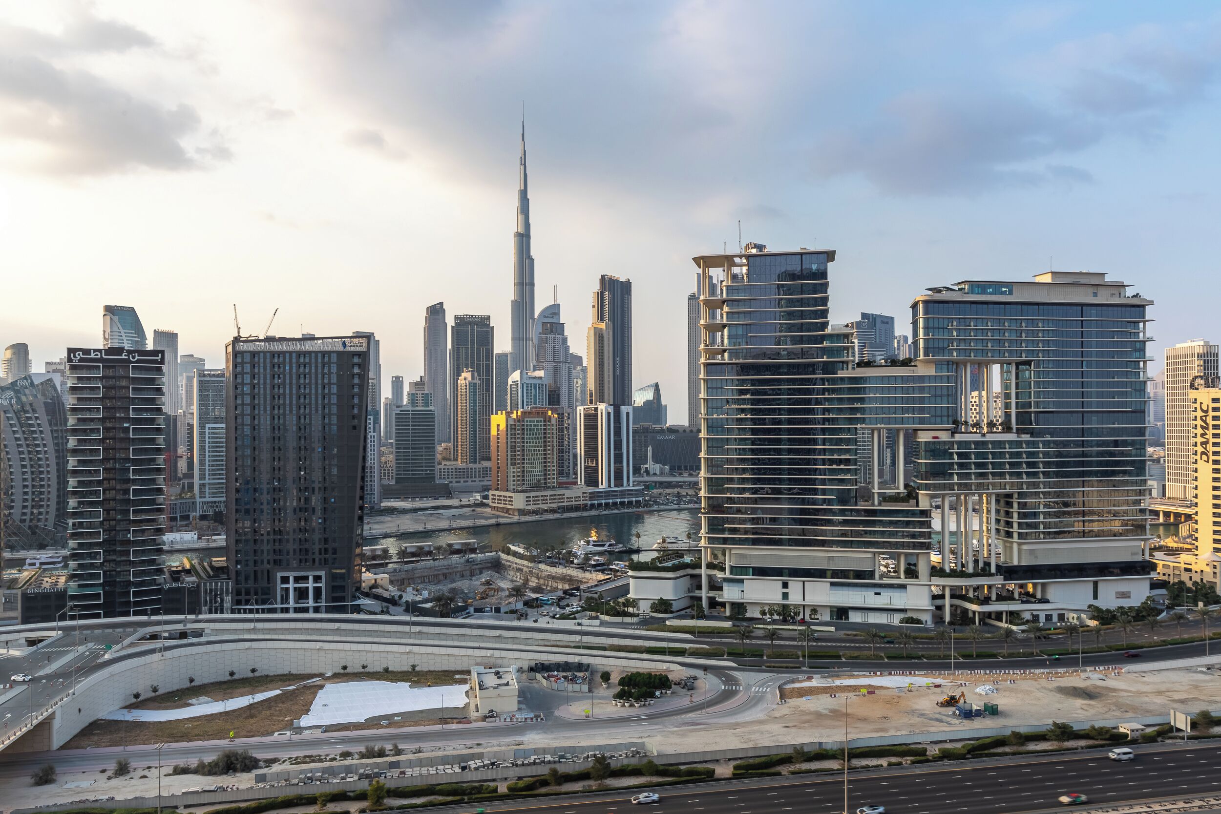 A cityscape with modern high-rise buildings, including a prominent skyscraper.