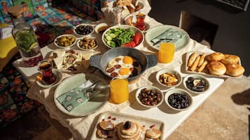 A breakfast table with various dishes, including eggs, bread, and fruit.