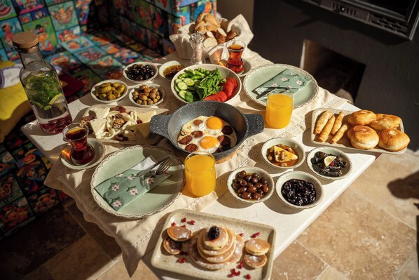 A breakfast table with various dishes, including eggs, bread, and fruit. - Yund 1922 (Ayvalik)