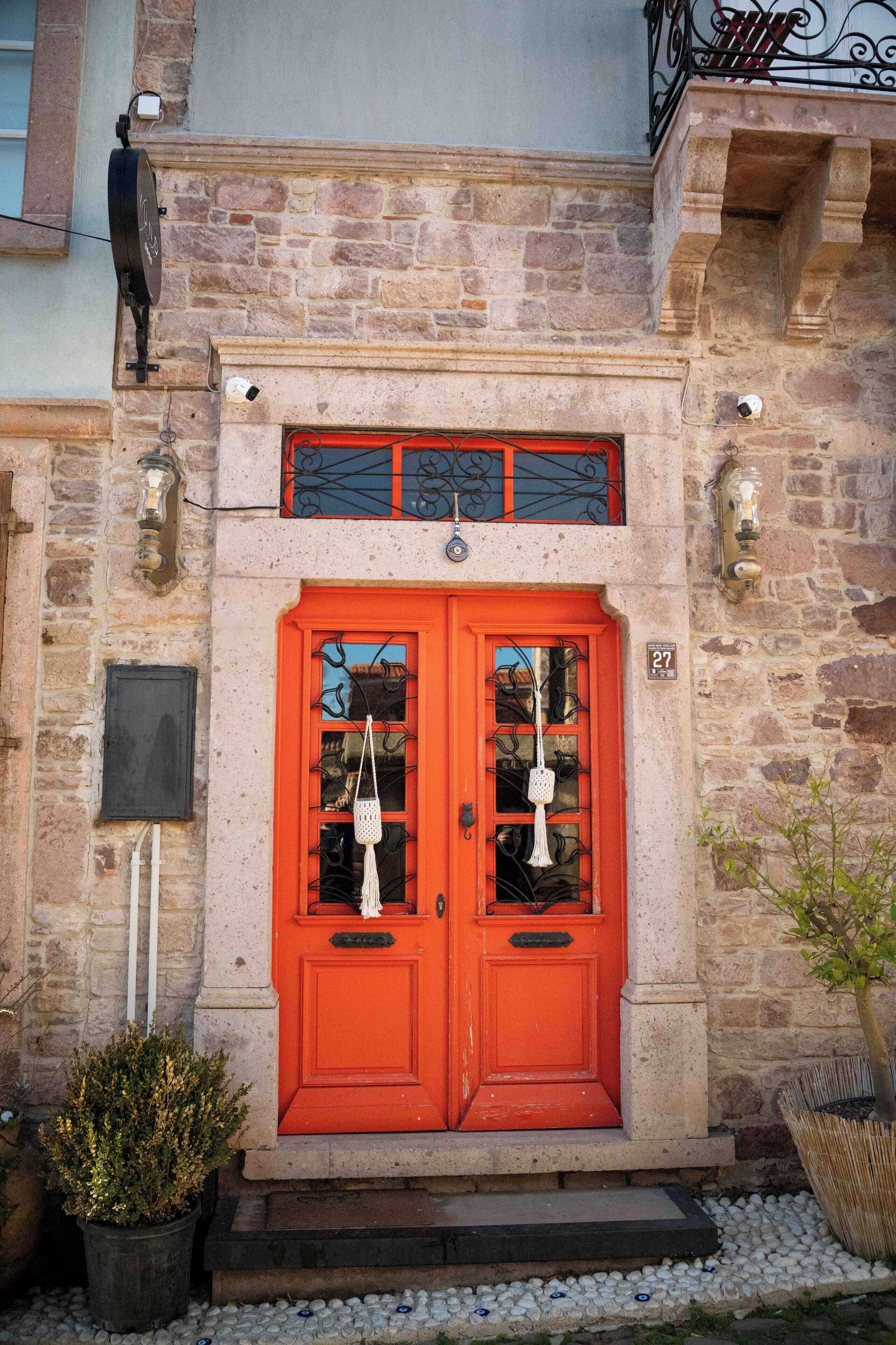 A two-story building with a red door and a small balcony above it.