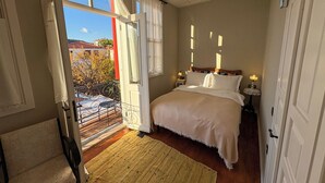 A bedroom with a bed, bedside tables, a window, and a balcony. - Yund 1922 (Ayvalik)