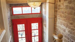 A staircase with a red door and a hanging light fixture. - Yund 1922 (Ayvalik)