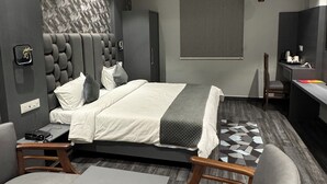 Un dormitorio moderno con cama, mesitas de noche, escritorio y silla.