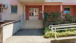 Entrada de un edificio con una escalera que conduce a una puerta marcada con el número '35A'.