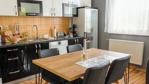 Una cocina moderna con armarios negros, una mesa de comedor de madera y sillas negras.