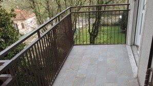 A balcony with a tiled floor and a metal railing.