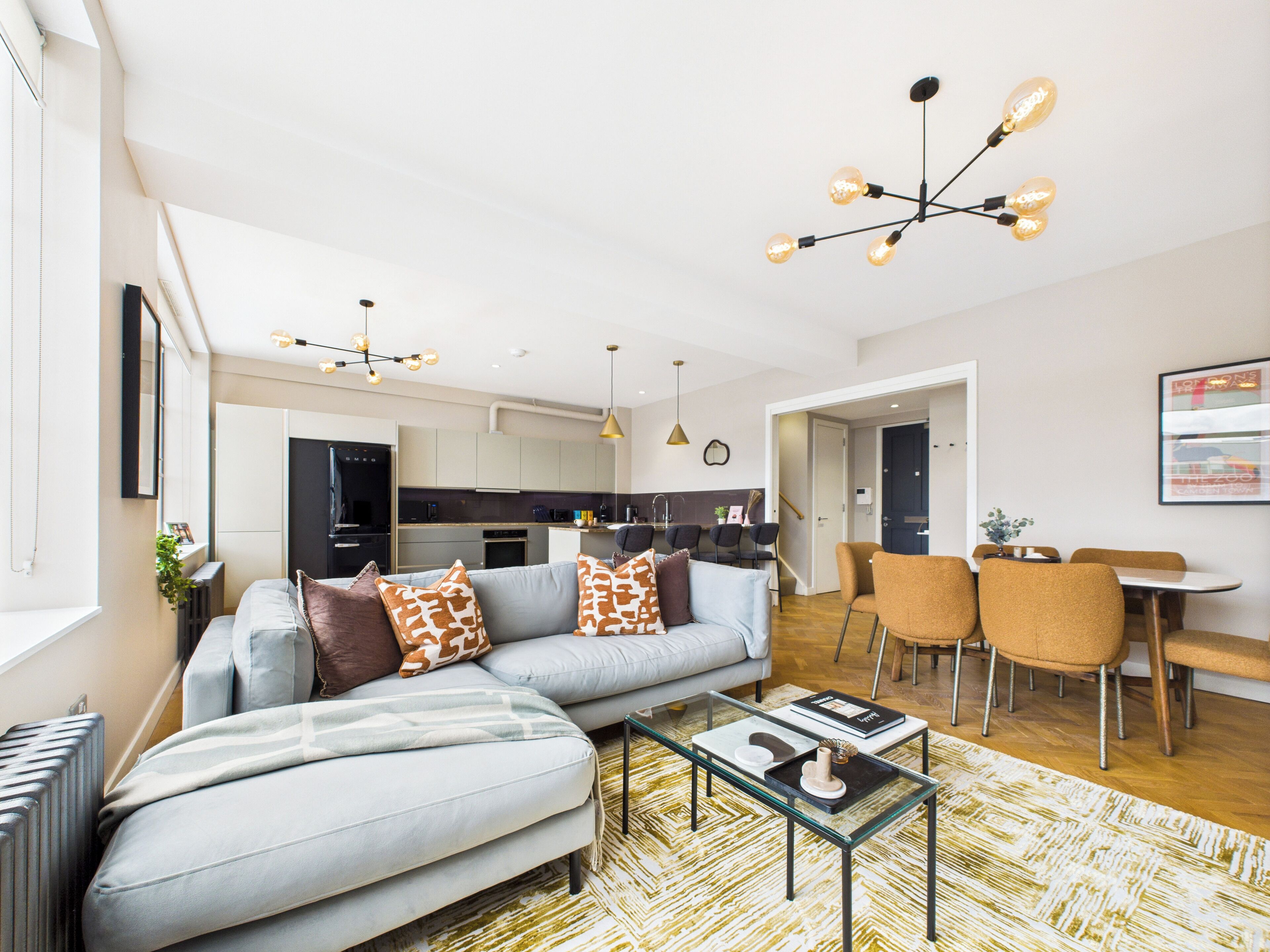 Una sala de estar moderna con sofá, mesa de centro y comedor.